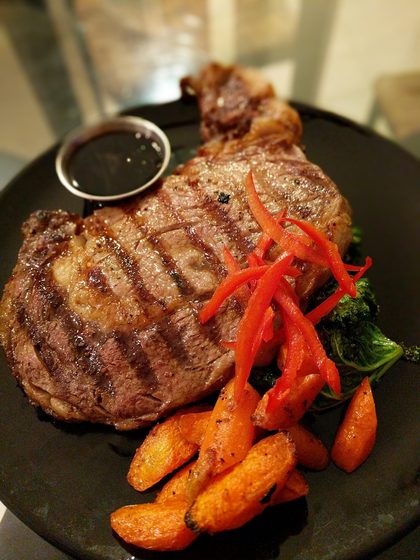 Grilled ribeye with blistered peppers and roasted carrots