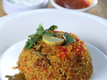 Spiced rice plated with sauces on the side