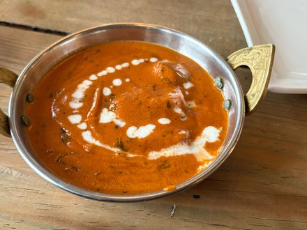 A curry simmered in a brass-handled pan