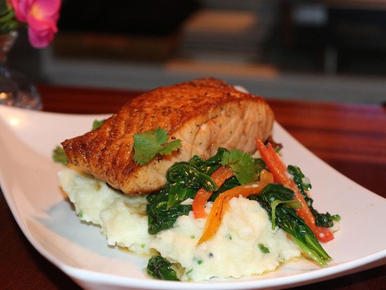 Seared salmon on chive mash with greens